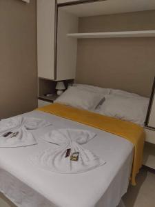普拉亚多斯卡内罗斯Eco Resort Praia dos Carneiros - Flat 116CM, apartamento completo ao lado da igrejinha的一张白色的大床,上面有黄色的毯子
