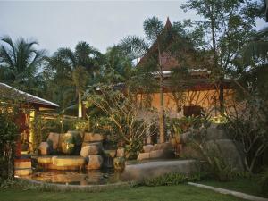 蔻立Fanari Khaolak Resort - Courtyard SHA Extra Plus的房屋前带池塘的花园