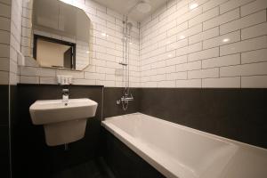 Uiwang25 Hotel的一间带水槽、浴缸和镜子的浴室