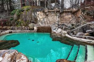 蒙特朗布朗Tremblant-Les-Eaux Le Contemporain by Gestion ELITE的一座带岩石墙的大型蓝色海水游泳池