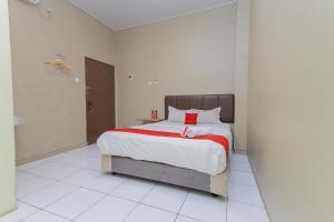 泗水RedDoorz near BG Junction Surabaya的一间卧室配有一张带红色枕头的大床