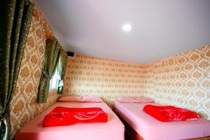 Ban Maeo Thap Boekไร่รักดอย ภูทับเบิก的小客房内的两张床,配有红色床单