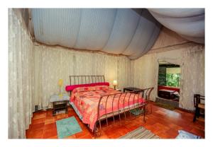 维特利Grassroots Wayanad, Valley-view Tents的一间卧室配有一张红色棉被的床
