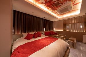 东京HOTELみなと-MINATO-的一间卧室配有一张带红色枕头的大床