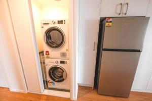 安特兰斯蓝礁湖海滩度假酒店的厨房里配有洗衣机和烘干机,旁边是冰箱