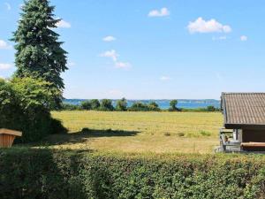 斯文堡8 person holiday home in Svendborg的享有田野和树屋的景色