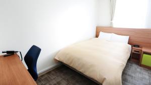 广岛广岛米尔帕曲酒店的一间卧室配有一张床、一张桌子和一把椅子