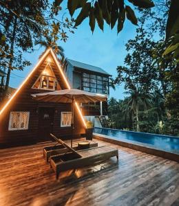 TayabasA House Lucban Resort & Spa的一个带长椅和遮阳伞的木制甲板