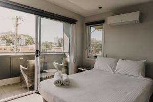 穆卢拉巴盐水别墅 - 乐宠住宿的一间带白色床的卧室和一个阳台