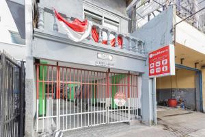 泗水RedDoorz near Mayapada Hospital Surabaya的阳台上带红色鞋门的建筑