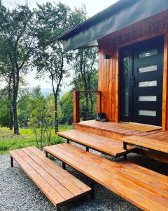 科马尔尼克MoodySun Studio, remote tiny home的小木屋前面设有2张长椅