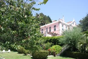 辛特拉辛特拉花园酒店的粉红色的房子,前面有一个花园