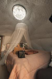 Mon JamSkypruek Luu Hlee ลุฮลี的配有吊灯的帐篷内一间卧室,配有一张床