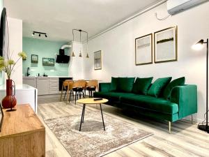 蒂米什瓦拉Sunset View Apartment的一间带绿色沙发的客厅和一间厨房