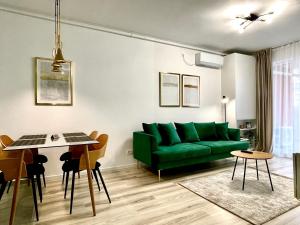 蒂米什瓦拉Sunset View Apartment的客厅配有绿色沙发和桌子