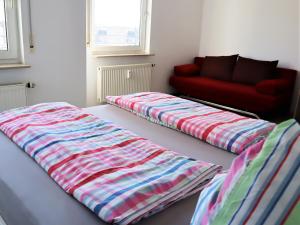 莱比锡Exklusive Wohnung mit Dachterrasse in Schleußig的配有红色沙发的客房内的两张床
