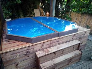 利布尔讷Chalet avec spa à Libourne proche St-Emilion的木甲板上的一个热水浴缸