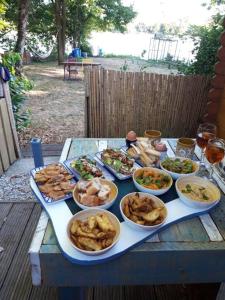 利布尔讷Chalet avec spa à Libourne proche St-Emilion的一张桌子上放着许多盘子的食物