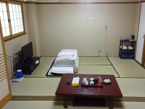 大阪今里旅馆的一间设有桌子和一张床的房间