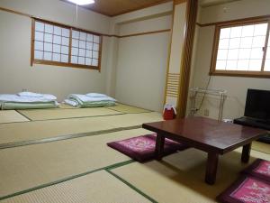 大阪今里旅馆的带桌子的房间和配有床的房间