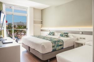 大加那利岛拉斯帕尔马斯Hotel Aloe Canteras的酒店客房设有两张床和窗户。