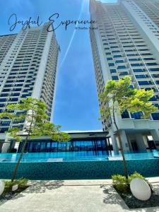莎阿南6Pax Suites Setia City Convention Trefoil Shah Alam SiS Homestay的两座高大的建筑,前面有树木