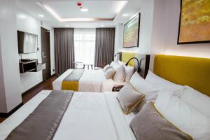 马尼拉ASN Boutique Residence的酒店客房设有两张床和电视。