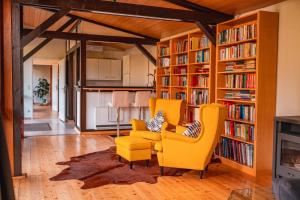 NeubulachGästehaus auf tollem Anwesen的客厅设有黄色椅子和书架
