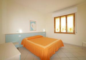 瓦达Appartamenti Manuela的一间卧室配有橙色的床和窗户。