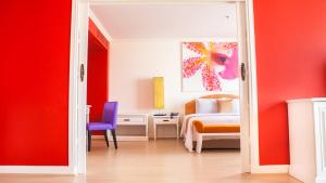 曼谷彤塔拉江景酒店的一间设有床铺的房间和一间带红色墙壁的卧室