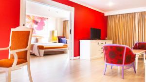 曼谷彤塔拉江景酒店的一间卧室设有红色的墙壁、一张床和镜子