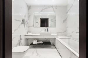 克莱佩达VICTORIA Hotel Klaipėda的白色的浴室设有水槽和卫生间。