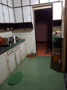 塞恩2BHK Flat Available for Wedding Guests, Home stay, Travelers - Mumbra的一间厨房,铺有绿色的地板