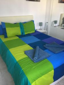 蒂亚斯Los Gracioseras 2 Bed Apt no 218 - AC, WIFI, UK TV的床上铺有多彩的床单和毛巾