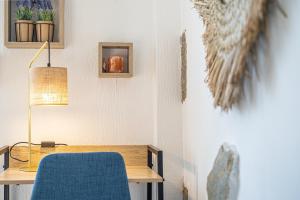 里摩日Petit nid douillet - Welc'Home的一张带蓝色椅子和一盏灯的桌子