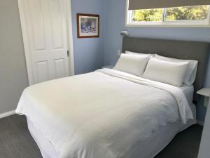 ComboyneApple Tree Cottage - Comboyne Mountain Cottages的白色的床、白色枕头和窗户