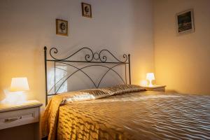 阿夸彭登泰Agriturismo Casale le Crete的卧室内的一张床位,配有两张桌子和两盏灯