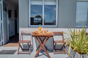 米拉玛Riviera del Sur - Apart hotel的一张带两把椅子的木桌和一瓶葡萄酒
