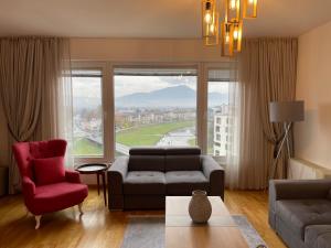 萨拉热窝شقة نهر اليجا的带沙发和红色椅子的客厅