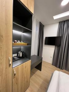 萨拉热窝OLYMPIC 84 Apartments的一间带一张床的房间和一间带电视的厨房