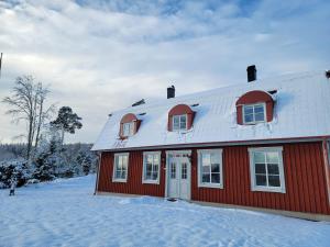 穆尔舍Villa Näs - a modern country villa的雪中白色屋顶的红色房子