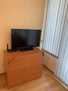 索非亚旅客之家旅馆的木质梳妆台上方的平面电视