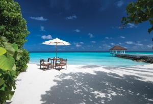 北马累环礁VARU by Atmosphere - Premium All Inclusive with Free Transfers的海滩上的桌椅和遮阳伞