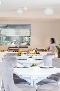 CustozaAgriturismo Maria Vittoria的一间设有白色桌椅的用餐室