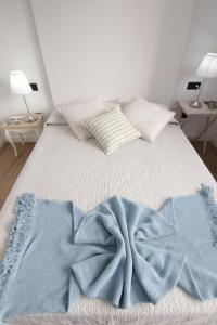 下布雷尼亚VV Casita El Paraíso的一张带蓝色毯子和枕头的床