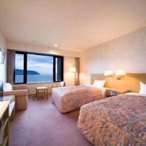 近江八幡市Kyukamura Ohmi-Hachiman的酒店客房设有两张床和大窗户。