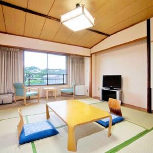 近江八幡市Kyukamura Ohmi-Hachiman的客厅配有桌椅和电视。