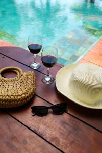 帕讷杜勒River Arc的一张桌子,上面放着两杯葡萄酒,一顶帽子和太阳镜