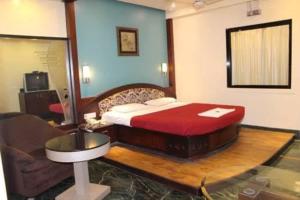 楠代德Ramakrishna International的一间卧室配有一张床、一张桌子和一个水槽