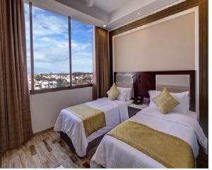 艾哈迈达巴德Regenta Inn Ranip Ahmedabad的酒店客房设有两张床和大窗户。